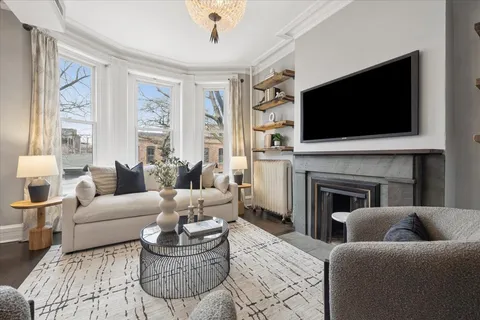 a living room with furniture a flat screen tv and a fireplace