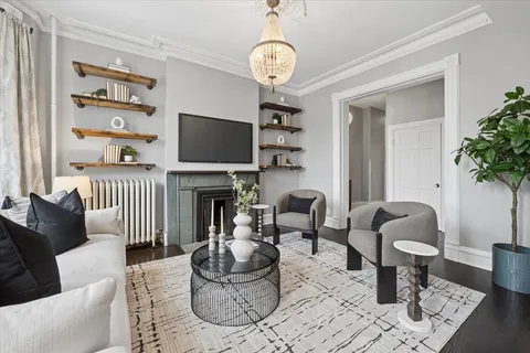 a living room with furniture a dining table and a potted plant