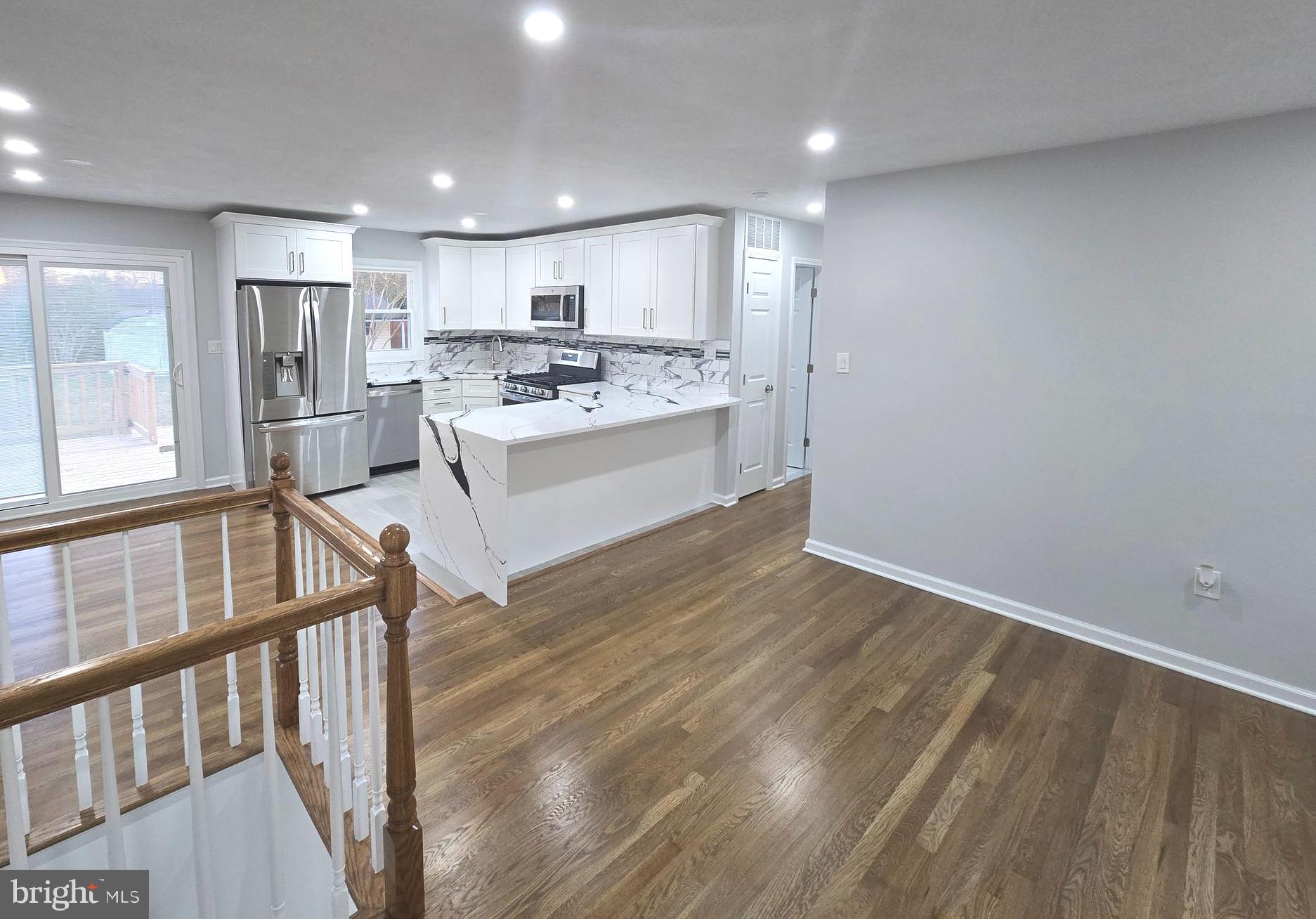 4813 Lawrence Street Alexandria, VA 22309 - Photo 13 of 66 a large white kitchen with wooden floors and stainless steel appliances
