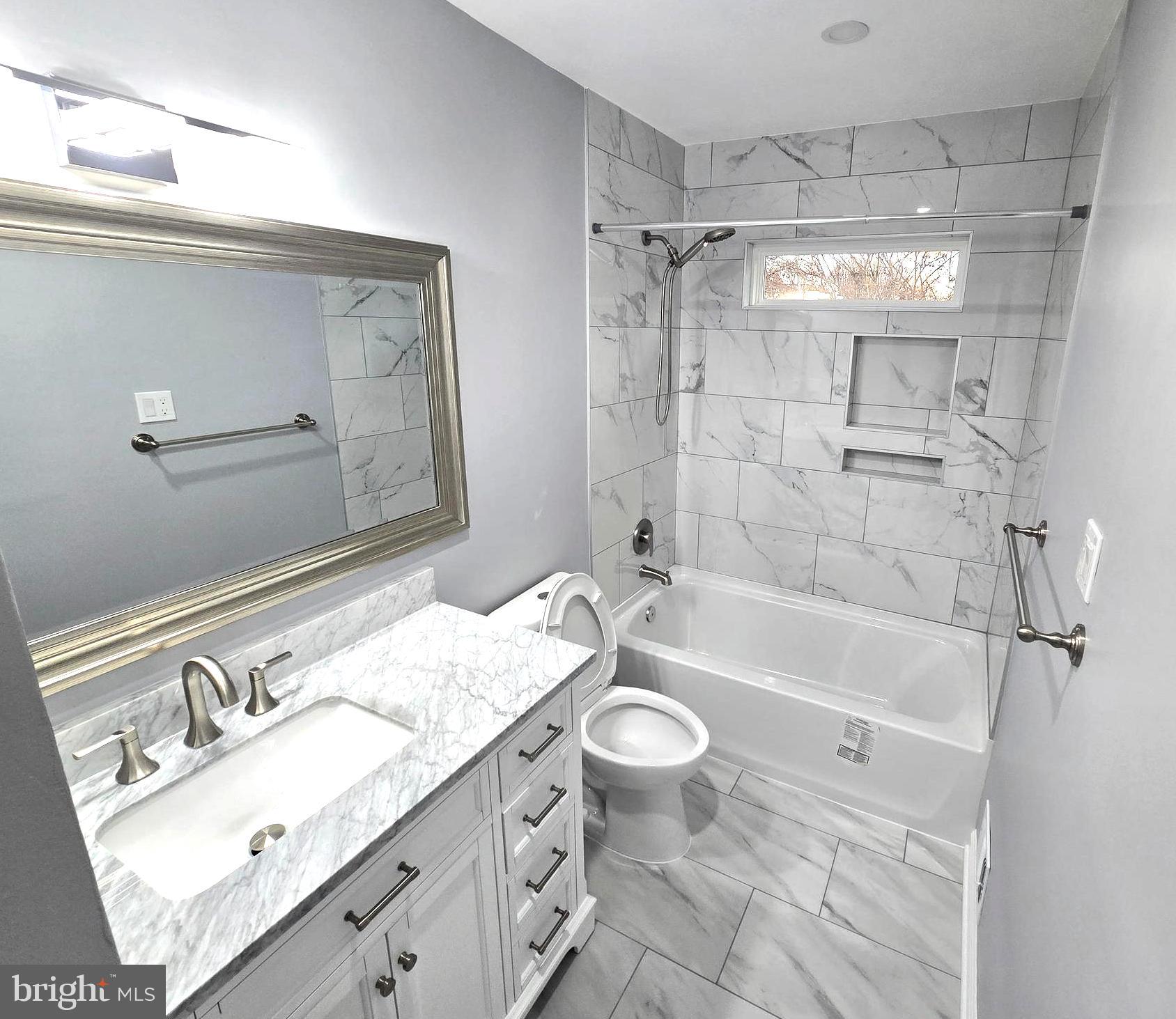 4813 Lawrence Street Alexandria, VA 22309 - Photo 22 of 66 a bathroom with a granite countertop sink a toilet a mirror and shower