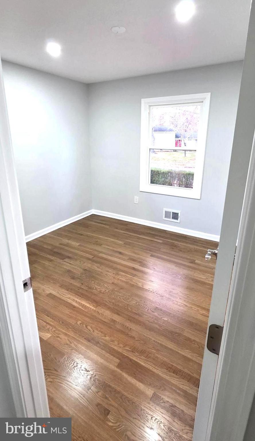 4813 Lawrence Street Alexandria, VA 22309 - Photo 23 of 66 an empty room with wooden floor and windows