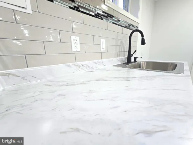 a view of a house with a small yard and large tree