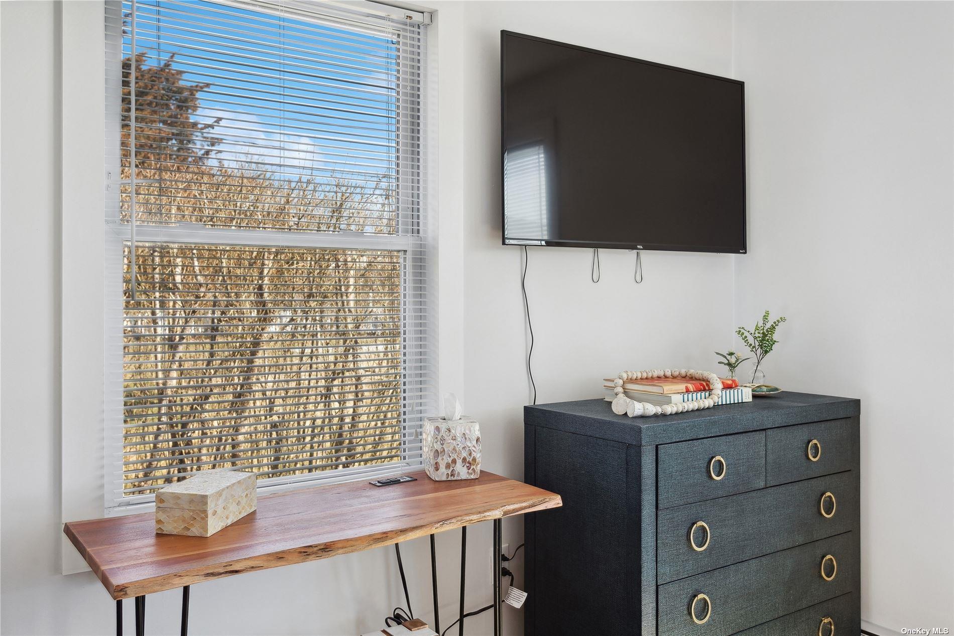 66 Library Avenue Westhampton Beach, NY 11978 - Photo 16 of 26 a room with a table chairs and a flat screen tv