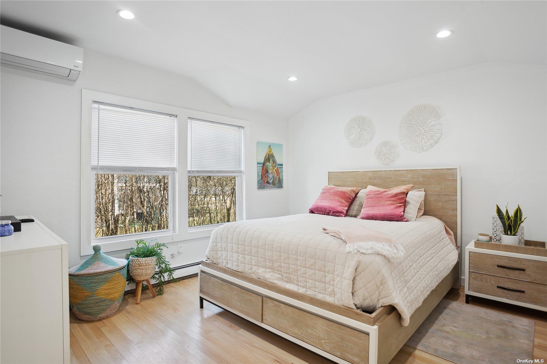 66 Library Avenue Westhampton Beach, NY 11978 - Photo 19 of 26 a bedroom with a bed and large windows