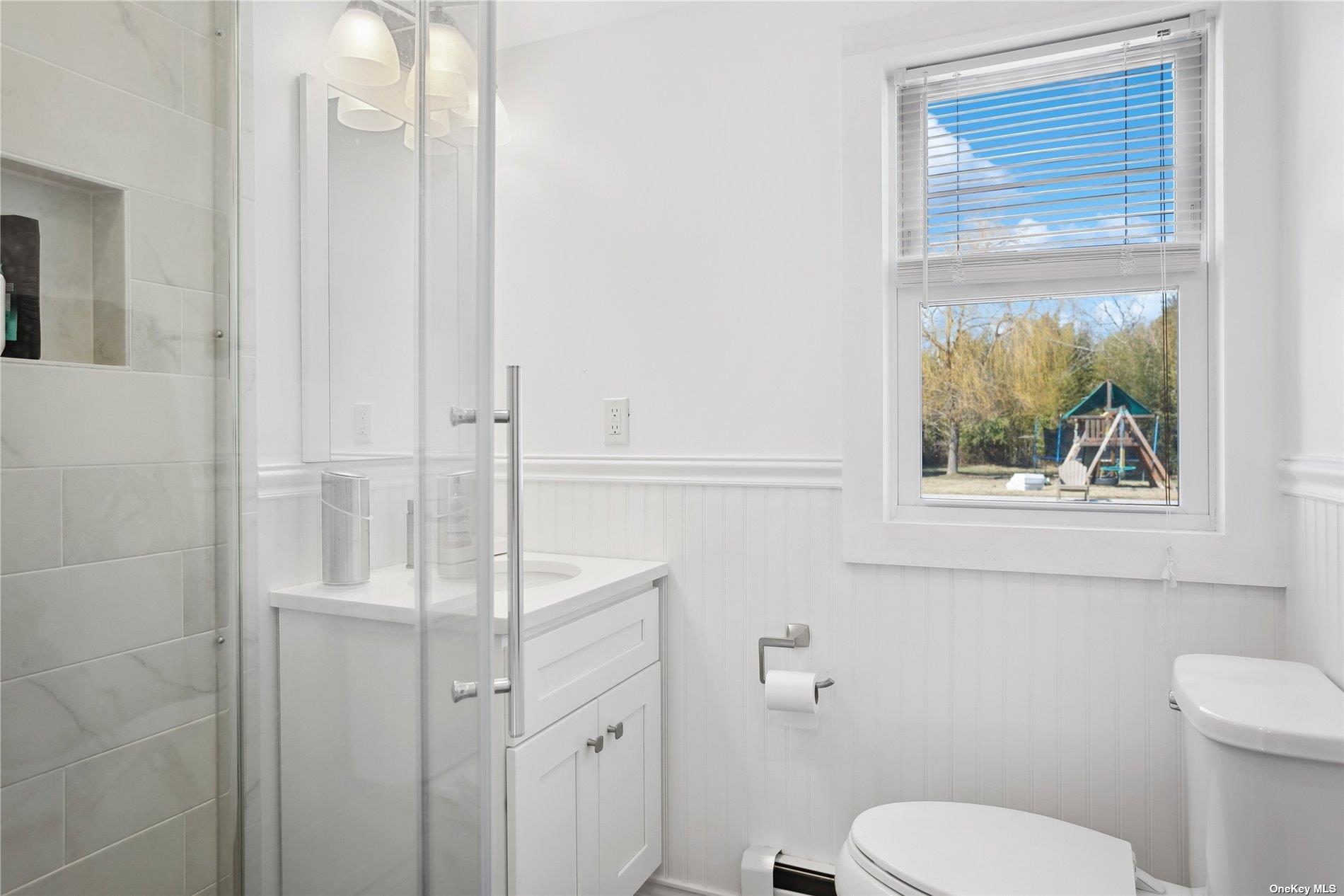 66 Library Avenue Westhampton Beach, NY 11978 - Photo 21 of 26 a bathroom with a toilet a sink and window