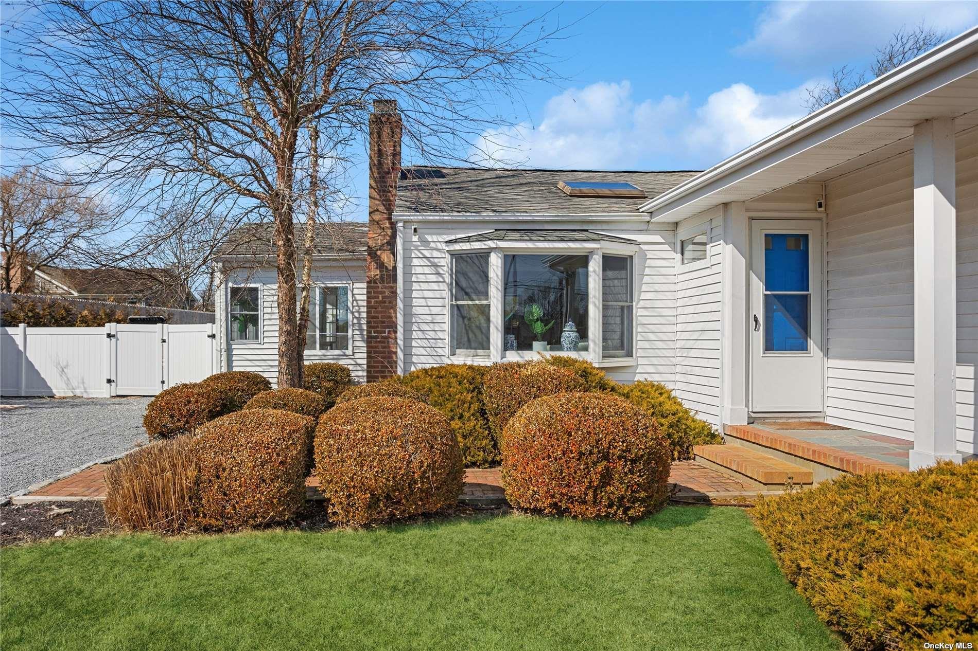 66 Library Avenue Westhampton Beach, NY 11978 - Photo 24 of 26 a house with green field in front of it