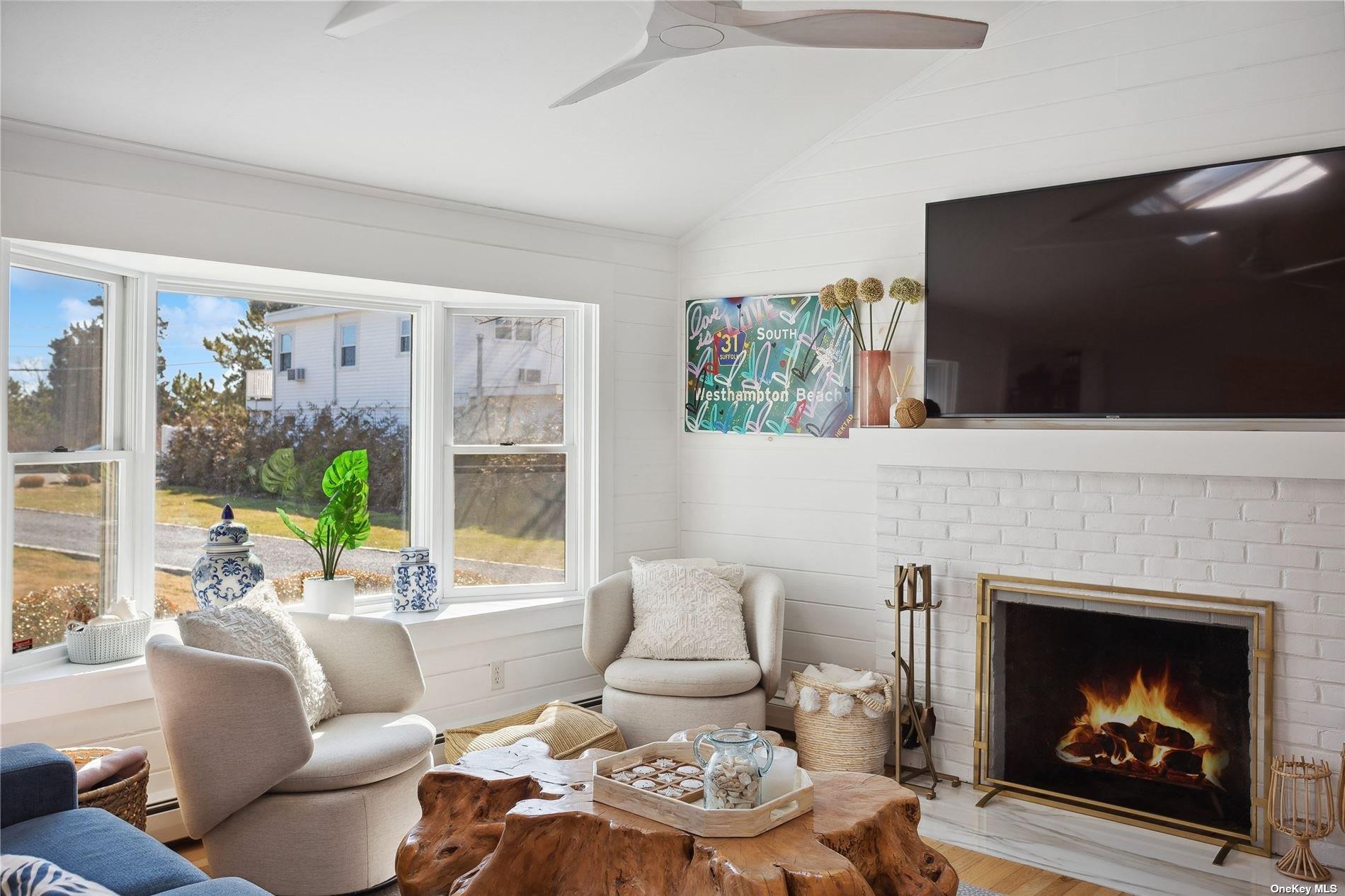 66 Library Avenue Westhampton Beach, NY 11978 - Photo 3 of 26 a living room with furniture a fireplace and a flat screen tv