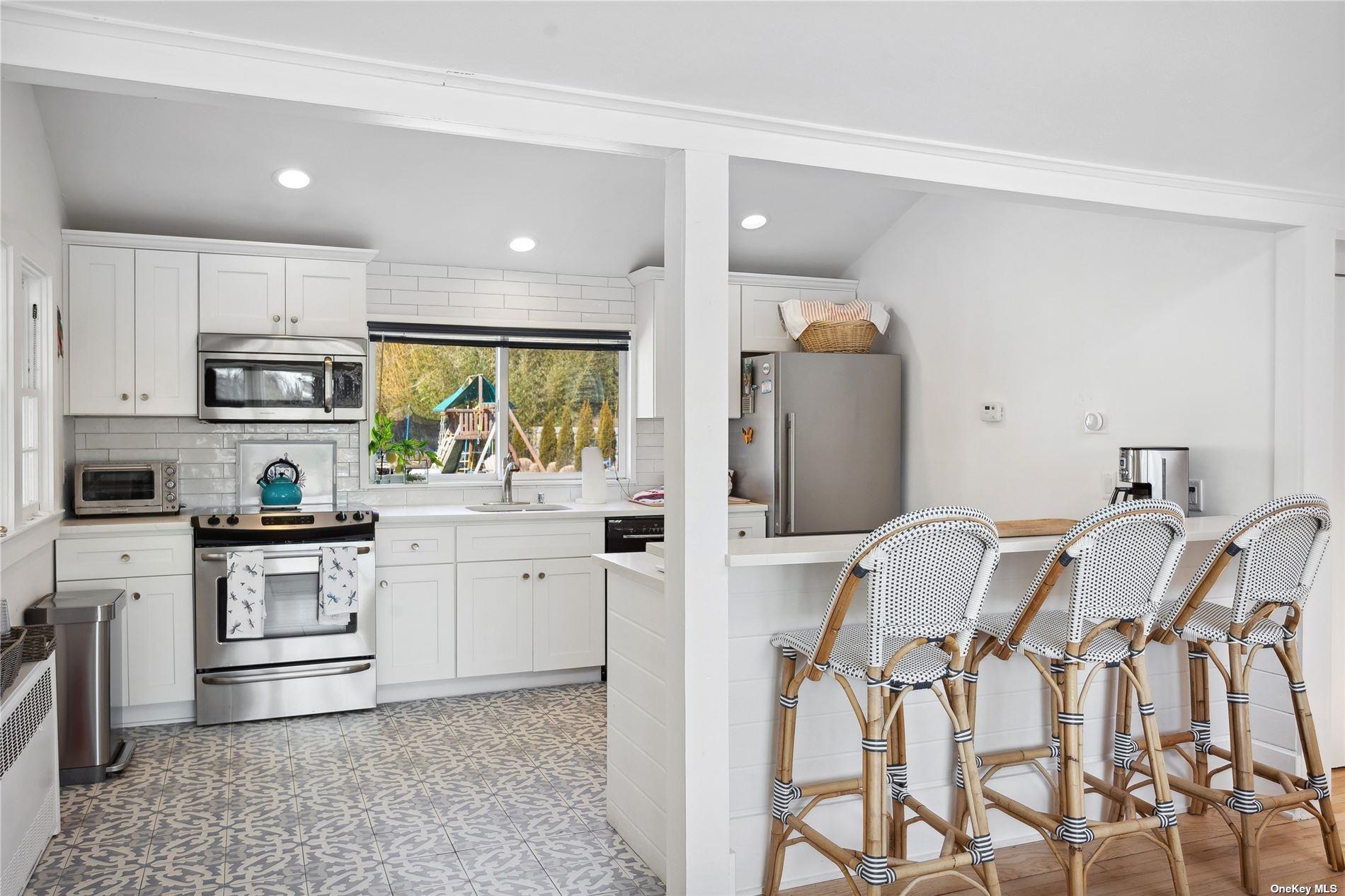 66 Library Avenue Westhampton Beach, NY 11978 - Photo 9 of 26 a kitchen with stainless steel appliances kitchen island granite countertop a refrigerator and microwave