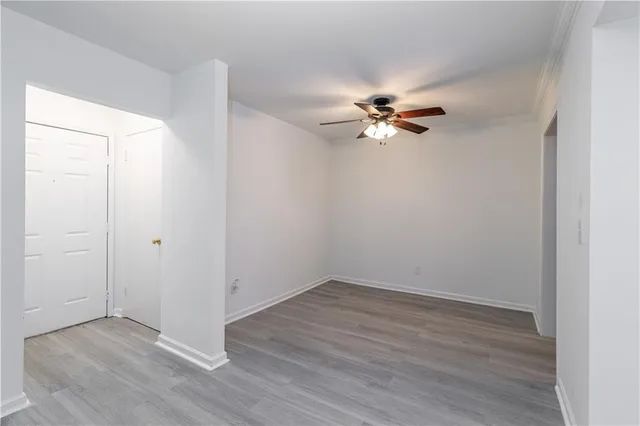 a view of a room with wooden floor and a ceiling fan