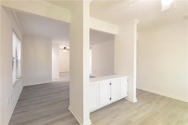 an empty room with wooden floor and windows