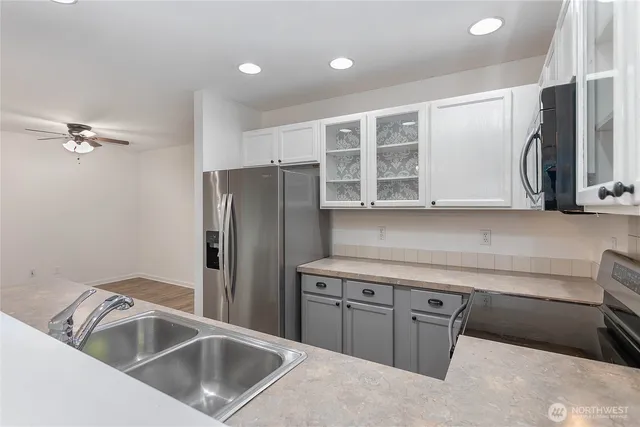 a kitchen with a refrigerator sink and cabinets
