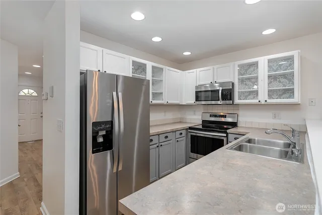 a kitchen with stainless steel appliances granite countertop a refrigerator stove microwave and sink