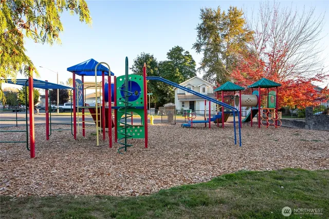 a view of outdoor space with lots of swings and slides