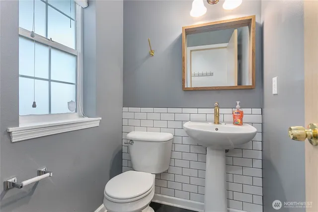 a bathroom with a sink a toilet and mirror