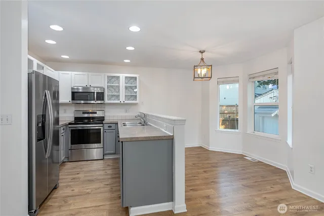 a kitchen with stainless steel appliances kitchen island granite countertop a stove and a refrigerator