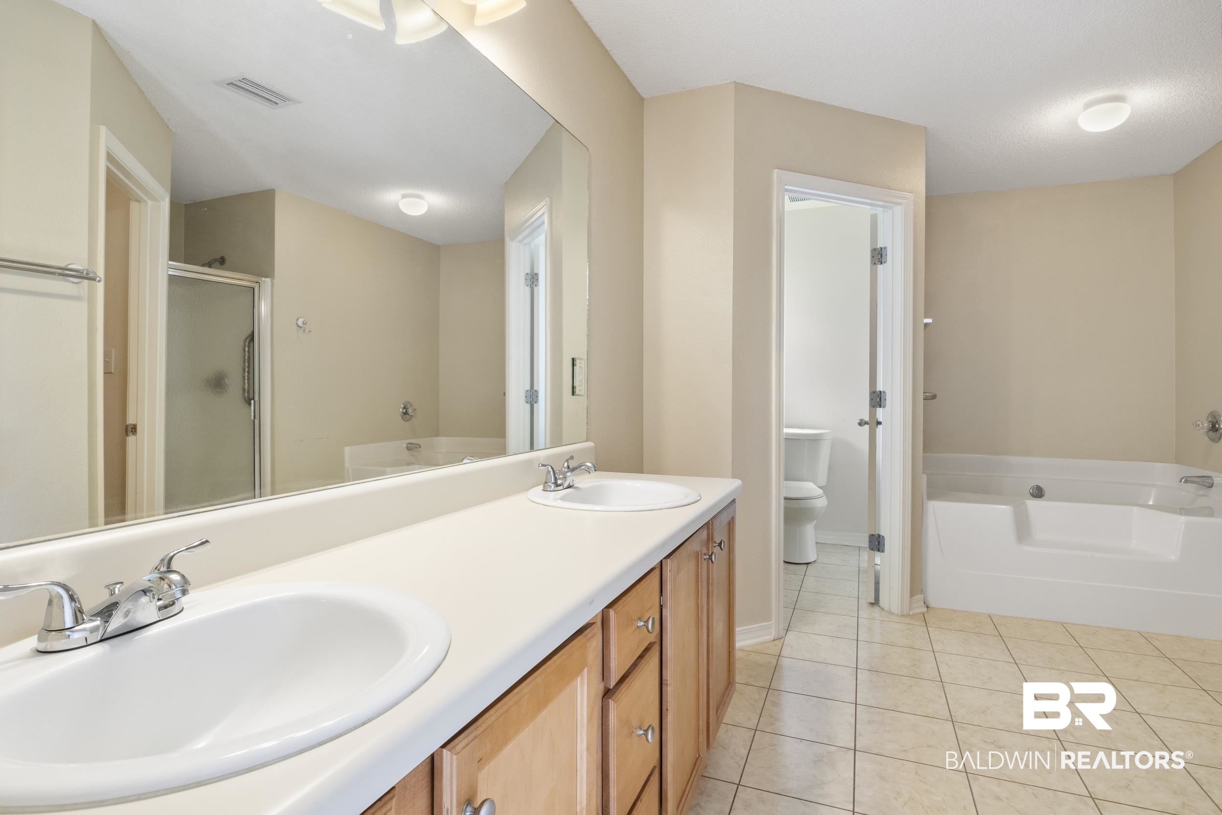 9610 Watkins Drive Fairhope, AL 36532 - Photo 8 of 26 Full bathroom with tile patterned floors, plus walk in shower, toilet, and double sink vanity