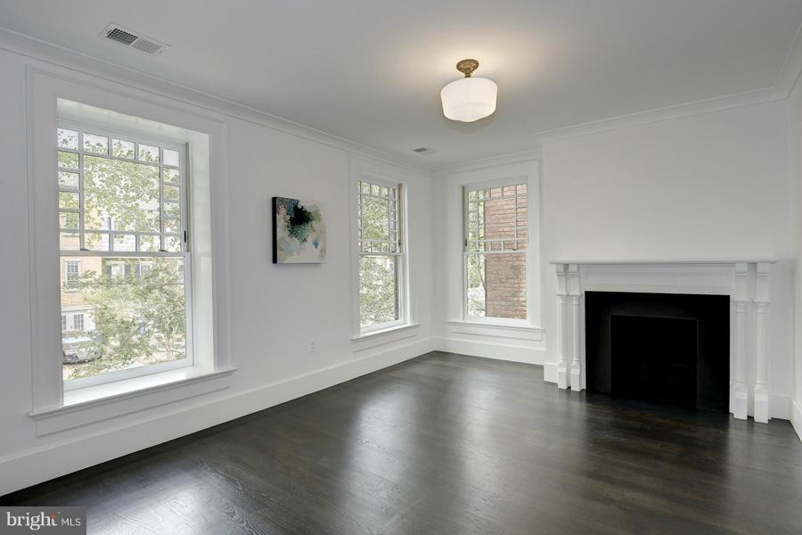 541 7th Street Southeast Washington, DC 20003 - Photo 14 of 30 an empty room with wooden floor fireplace and windows