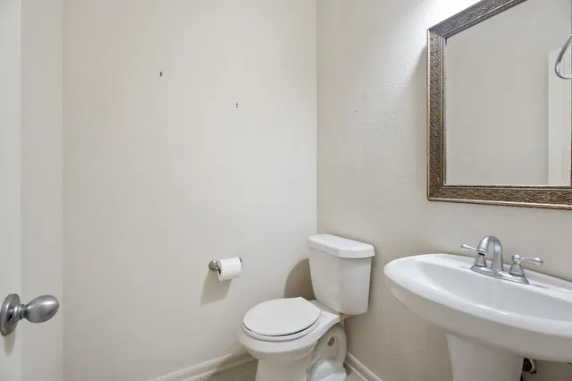 a white toilet sitting next to a bathroom sink
