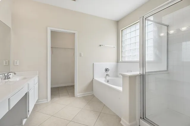a spacious bathroom with a tub sink shower and mirror