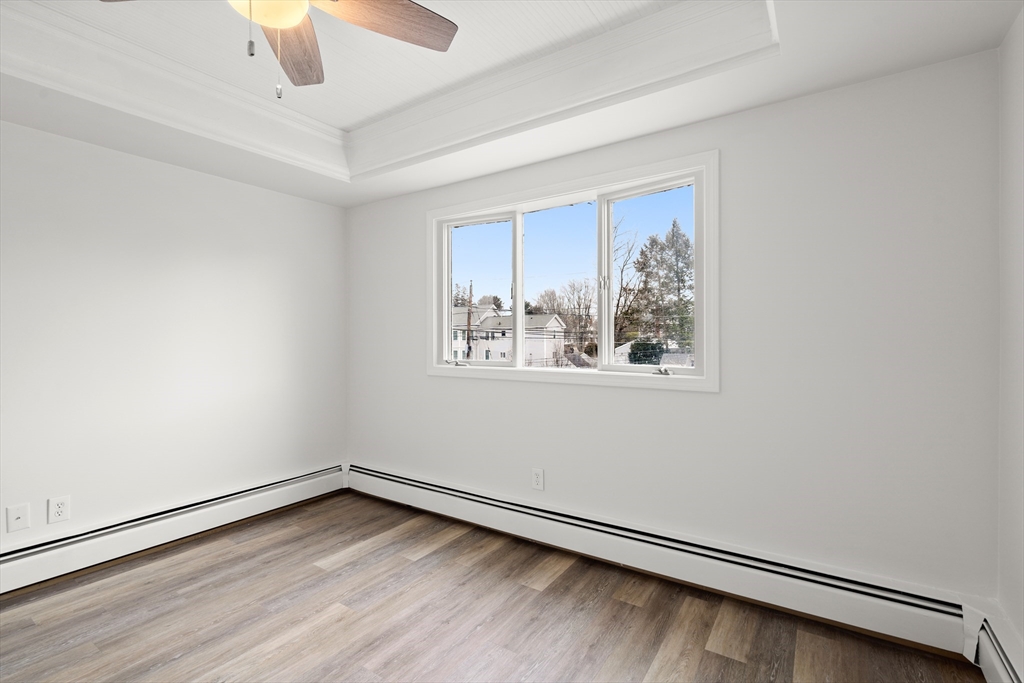 17 3rd Street, Unit 17 North Andover, MA 01845 - Photo 11 of 12 an empty room with a window and ceiling fan
