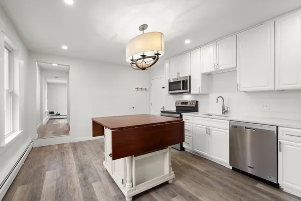 a kitchen with stainless steel appliances granite countertop a stove a sink and a microwave