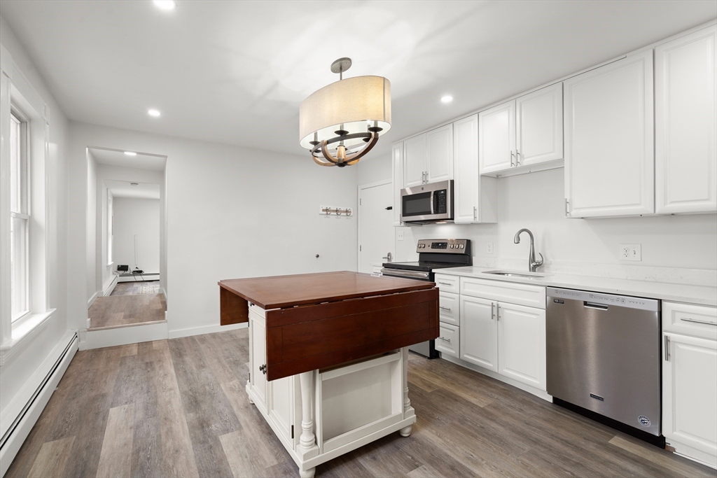 17 3rd Street, Unit 17 North Andover, MA 01845 - Photo 3 of 12 a kitchen with stainless steel appliances granite countertop a stove a sink and a microwave