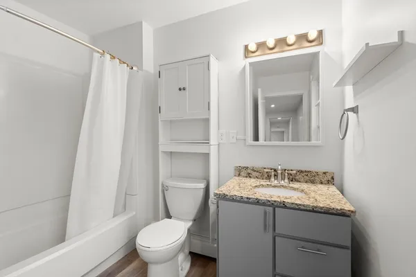 a bathroom with a granite countertop sink toilet and shower