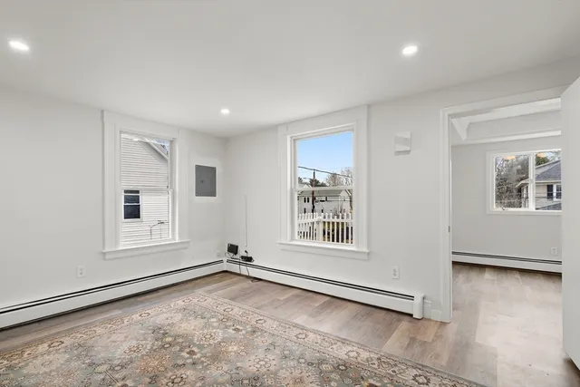 an empty room with wooden floor and fan