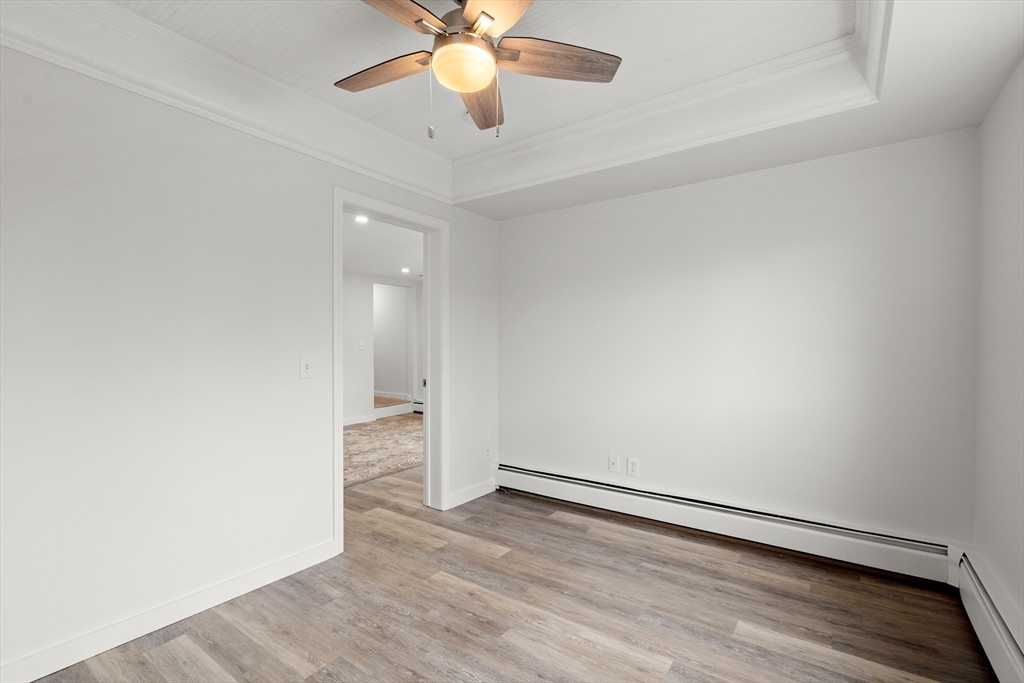 17 3rd Street, Unit 17 North Andover, MA 01845 - Photo 9 of 12 an empty room with wooden floor and fan