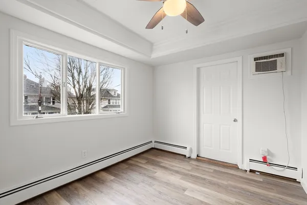 an empty room with a window and ceiling fan