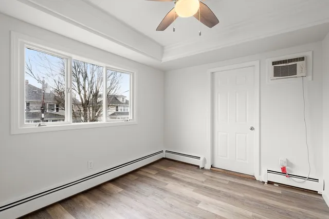 an empty room with a window and ceiling fan