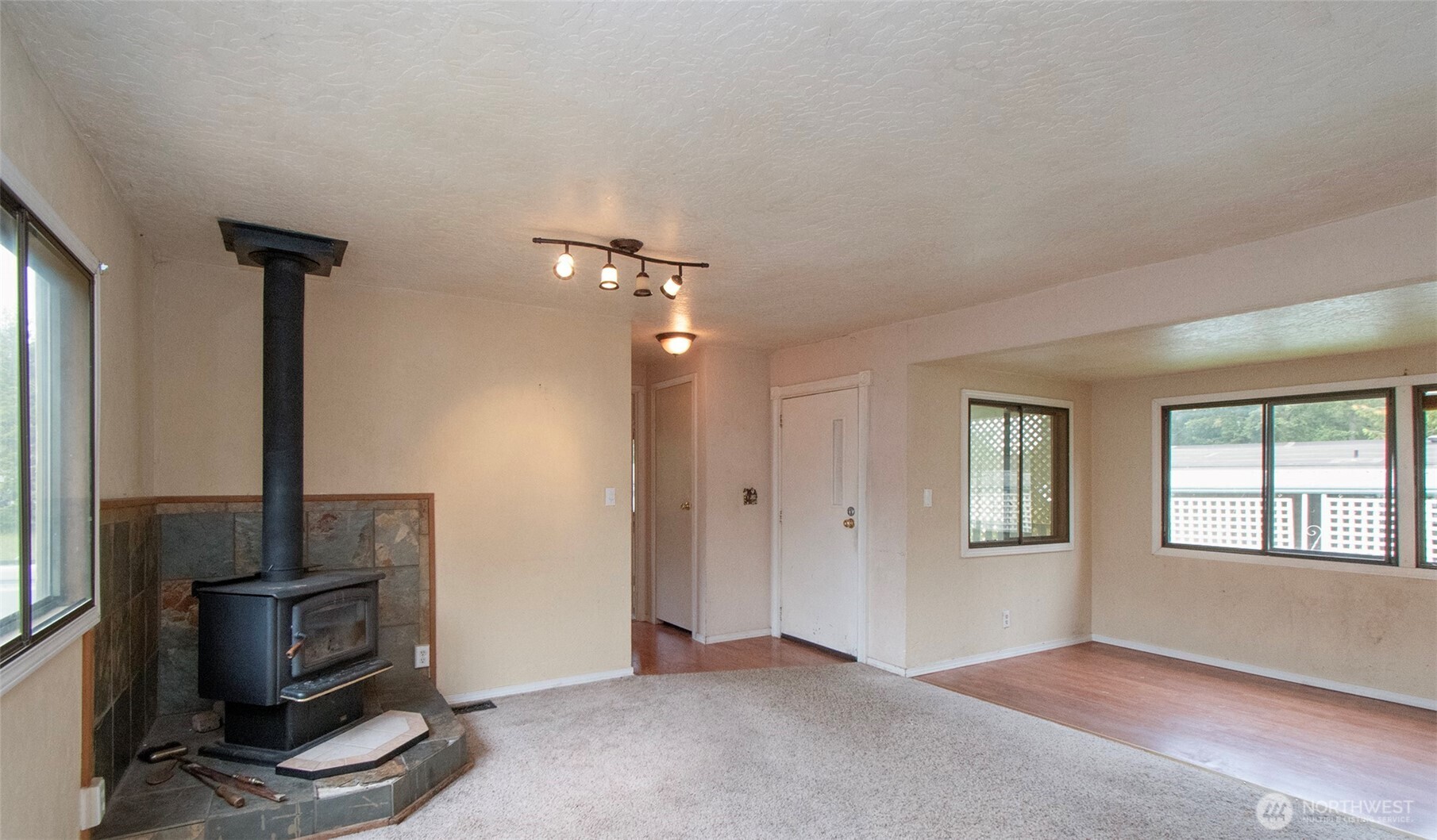 90 Baywood Village Road, Unit 34 Sequim, WA 98382 - Photo 8 of 40 a view of an empty room with a fireplace and a window