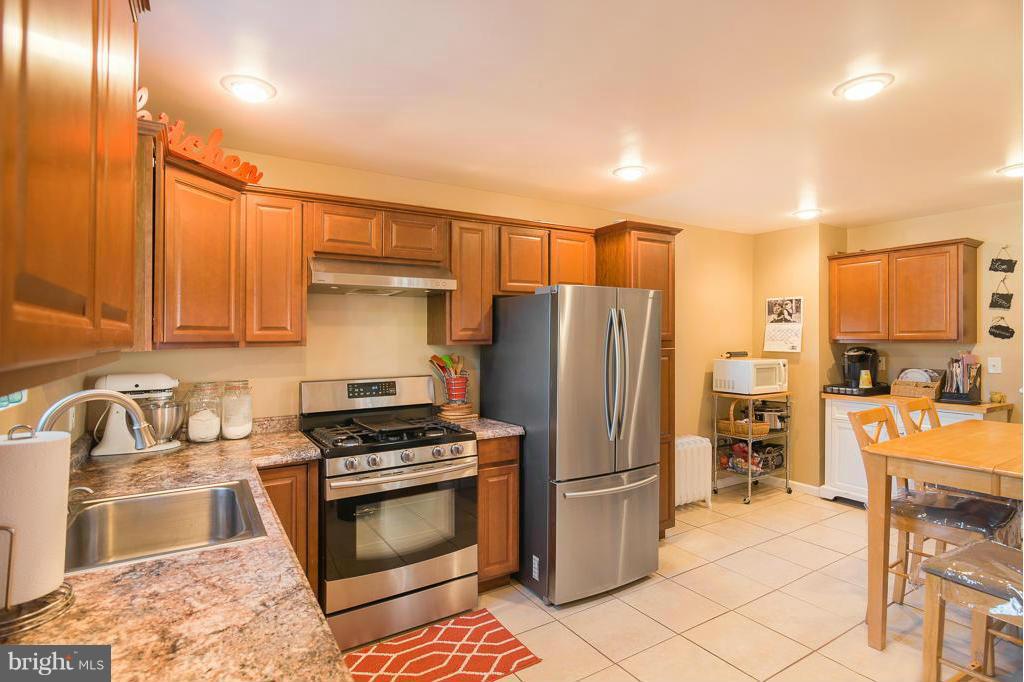 5014 Morello Road Baltimore, MD 21214 - Photo 1 of 29 a kitchen with granite countertop a refrigerator and a stove top oven