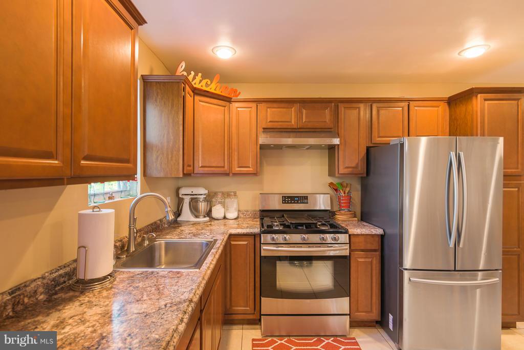 5014 Morello Road Baltimore, MD 21214 - Photo 3 of 29 a kitchen with granite countertop a refrigerator stove and sink