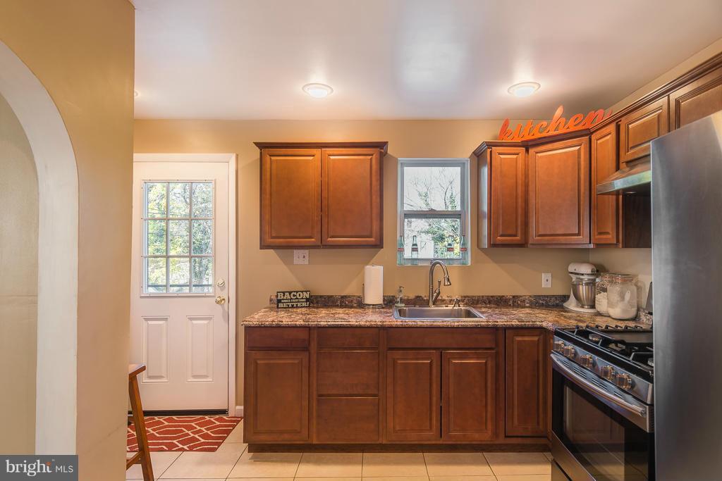 5014 Morello Road Baltimore, MD 21214 - Photo 4 of 29 a kitchen with granite countertop cabinets stainless steel appliances a sink and a window