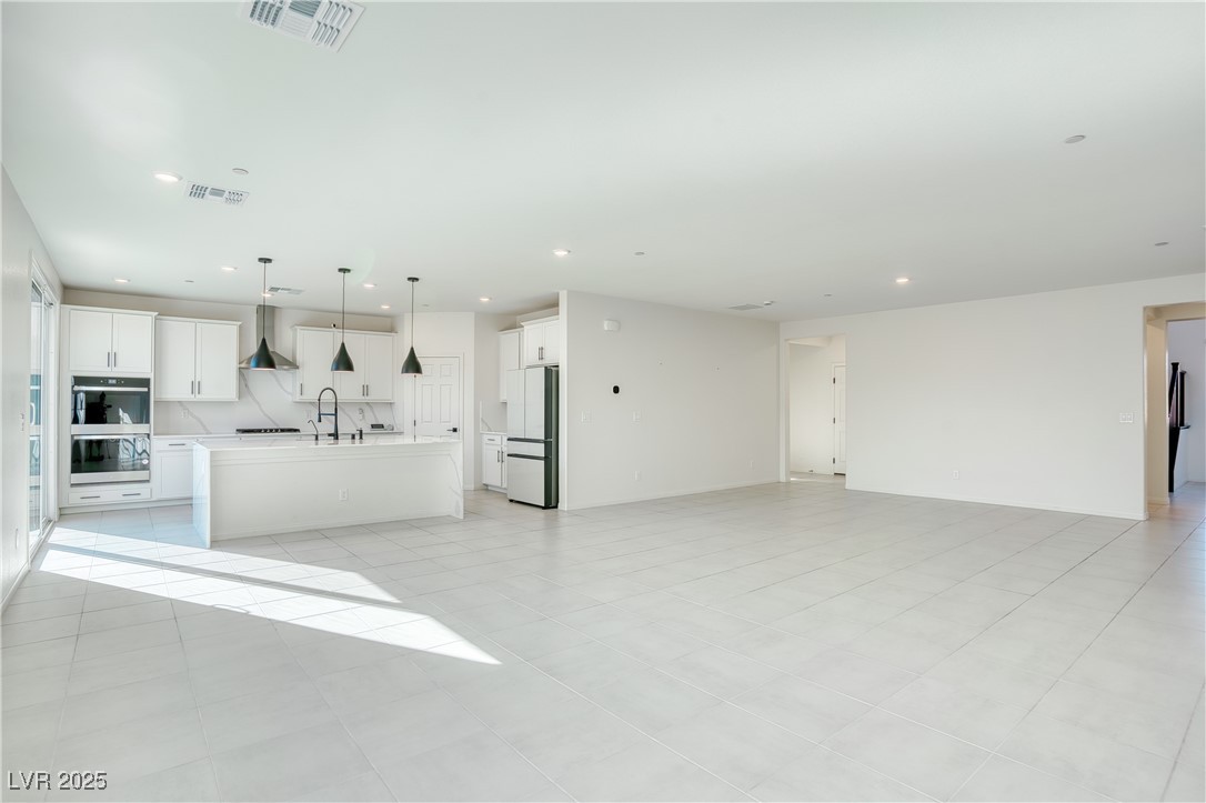 3777 Alla Rocca Avenue Henderson, NV 89044 - Photo 55 of 55 Kitchen featuring open floor plan, white cabinets, a kitchen island with sink, freestanding refrigerator, and recessed lighting