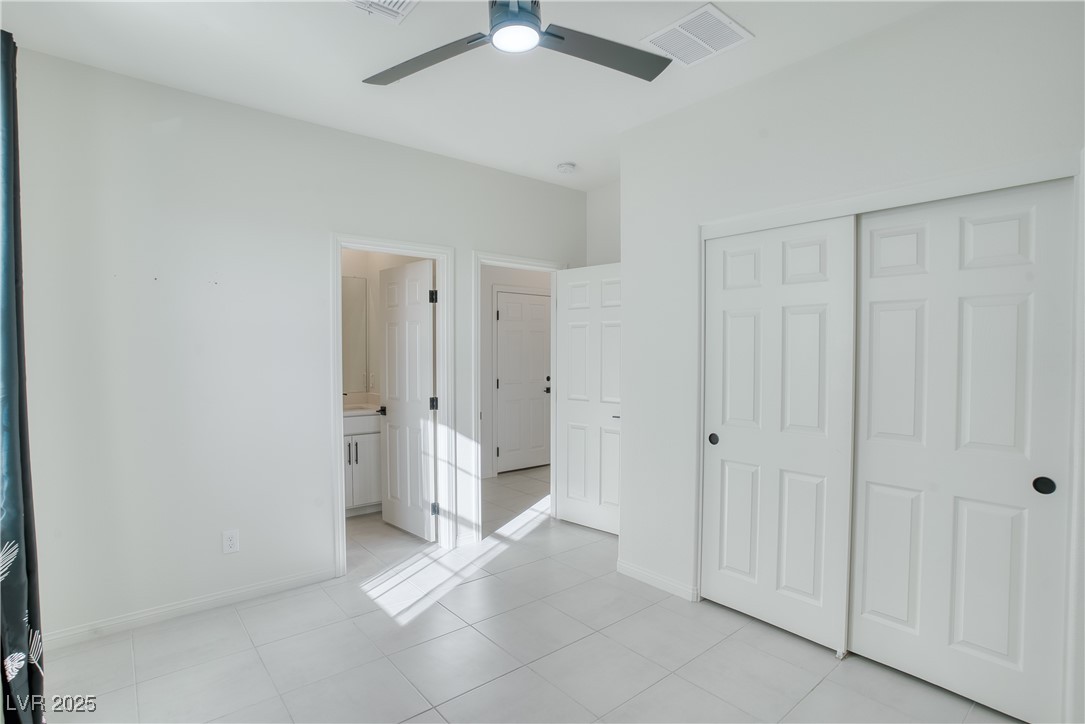 3777 Alla Rocca Avenue Henderson, NV 89044 - Photo 17 of 55 Unfurnished bedroom featuring light tile patterned flooring, a ceiling fan, a closet, and ensuite bathroom downstairs
