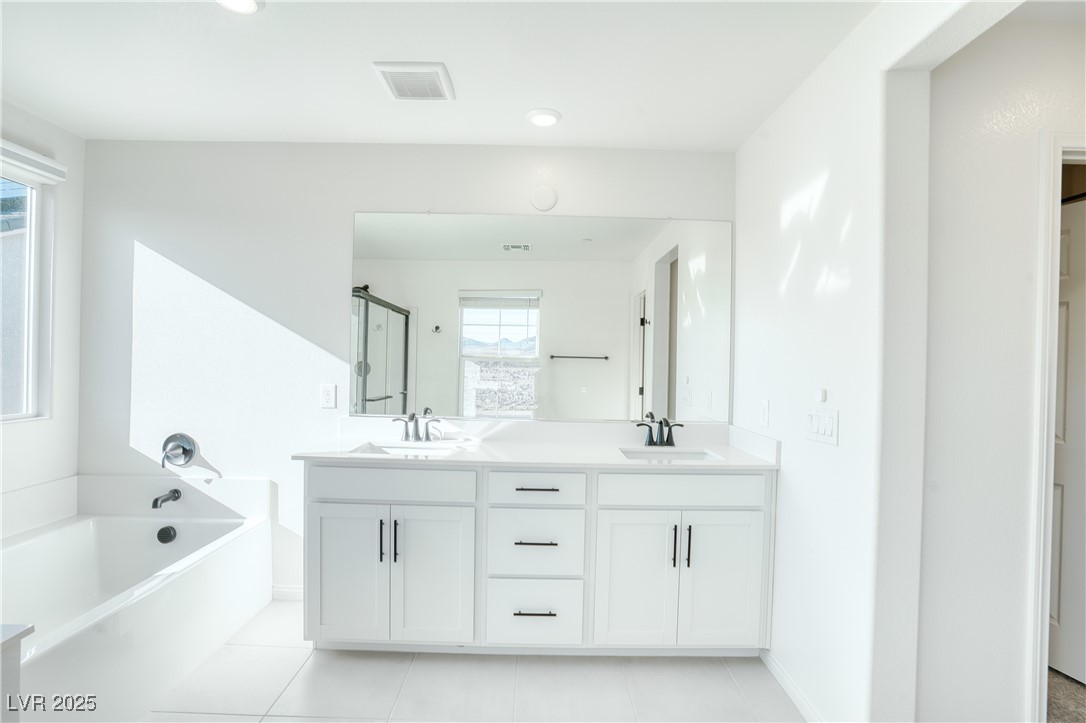 3777 Alla Rocca Avenue Henderson, NV 89044 - Photo 27 of 55 Full bathroom with a stall shower, double vanity, a garden tub, light tile patterned floors, and recessed lighting