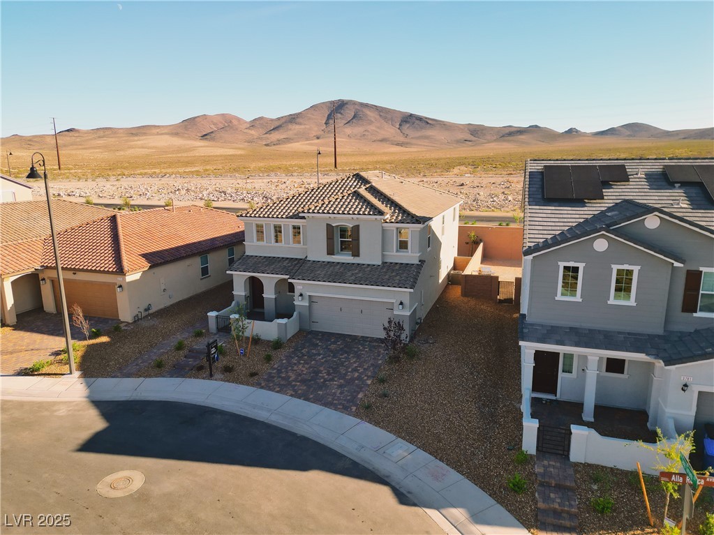 3777 Alla Rocca Avenue Henderson, NV 89044 - Photo 48 of 55 View of front of house with decorative driveway, a garage, a mountain view, stucco siding, and a porch