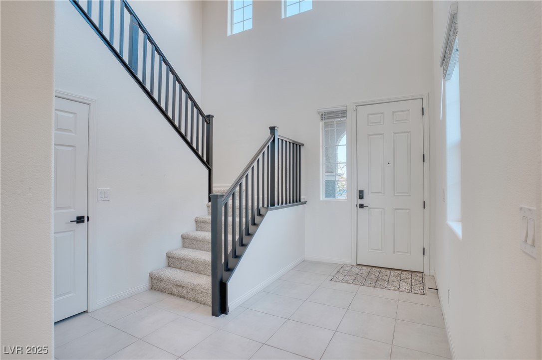 3777 Alla Rocca Avenue Henderson, NV 89044 - Photo 6 of 55 Foyer with plenty of natural light, stairs, light tile patterned flooring, and a towering ceiling