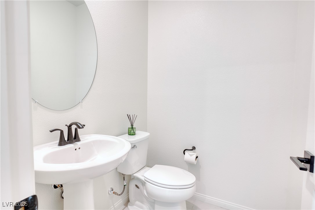 3777 Alla Rocca Avenue Henderson, NV 89044 - Photo 7 of 55 Bathroom with toilet and baseboards downstaris