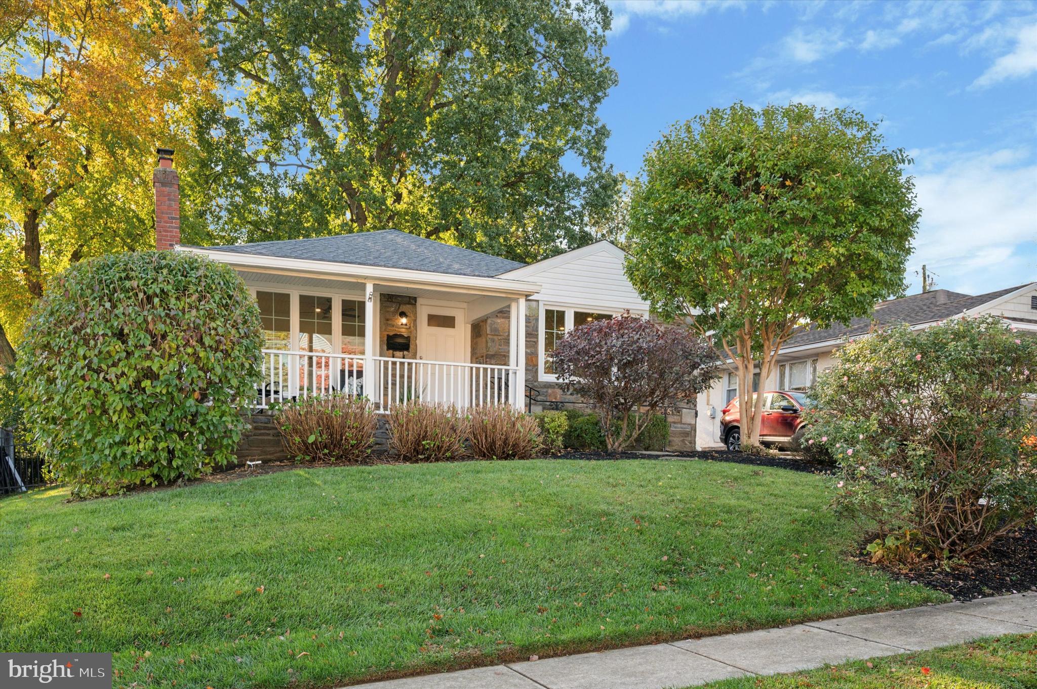 a front view of a house with a yard and trees