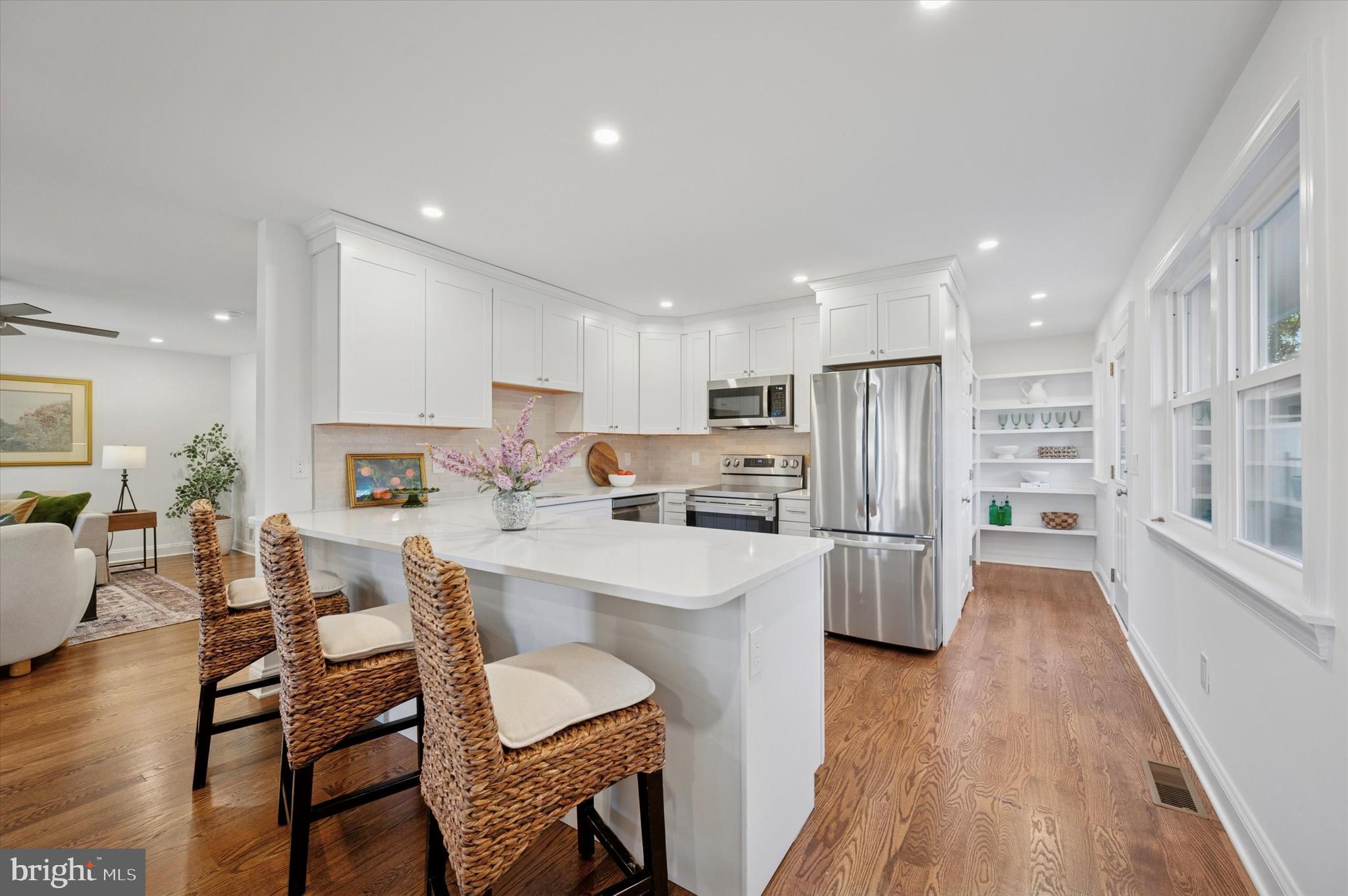 2308 Poplar Road Havertown, PA 19083 - Photo 11 of 25 a kitchen with stainless steel appliances a refrigerator a stove top oven a sink dishwasher and white cabinets with wooden floor