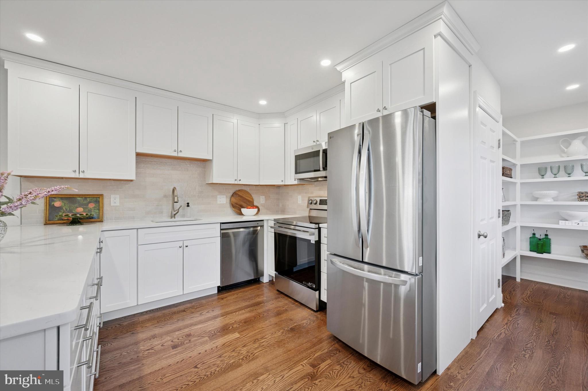 2308 Poplar Road Havertown, PA 19083 - Photo 14 of 25 a kitchen with a refrigerator a stove top oven and wooden floors