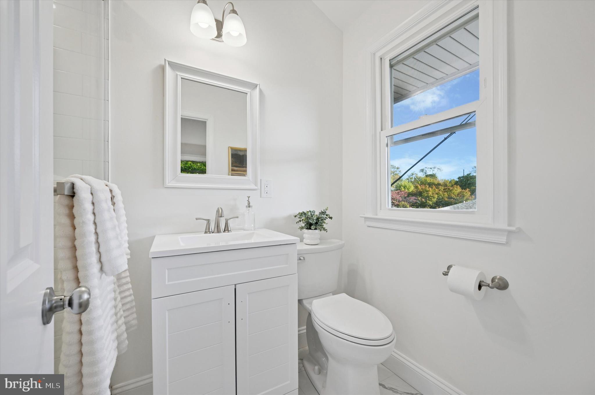 2308 Poplar Road Havertown, PA 19083 - Photo 20 of 25 a bathroom with a granite countertop toilet a sink a mirror a vanity and a window