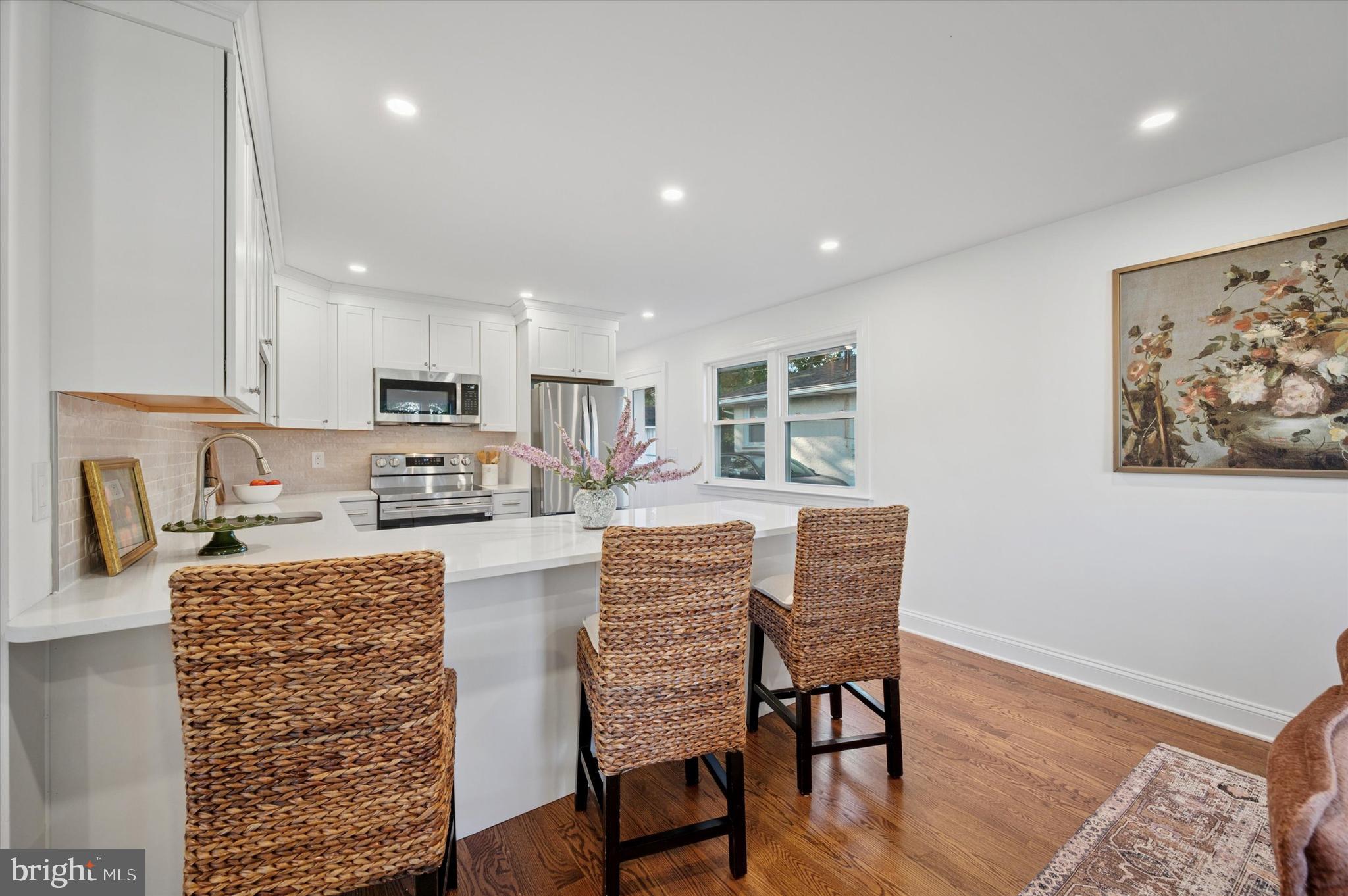 2308 Poplar Road Havertown, PA 19083 - Photo 10 of 25 a kitchen with stainless steel appliances granite countertop a stove top oven a refrigerator a sink and white cabinets with wooden floor