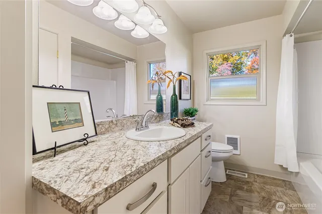 a bathroom with a granite countertop sink and a mirror