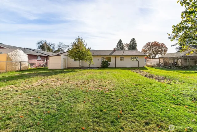 a view of a house with a big yard and large trees