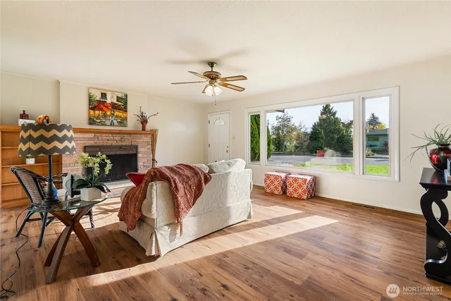 a living room with furniture fireplace and a large window
