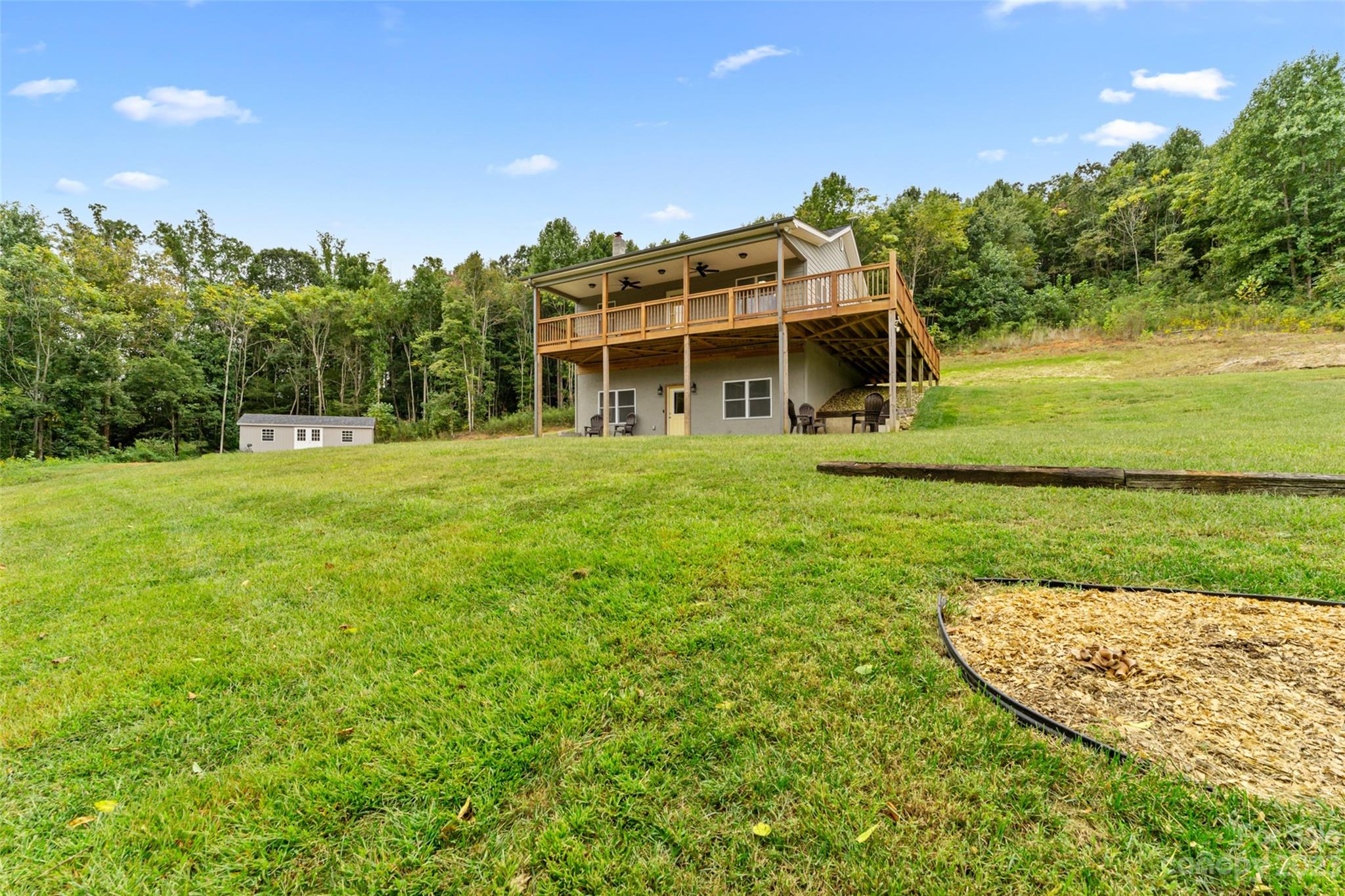 6363 Cheatham Ford Road Hiddenite, NC 28636 - Photo 12 of 32 a view of a big house with a big yard and large trees